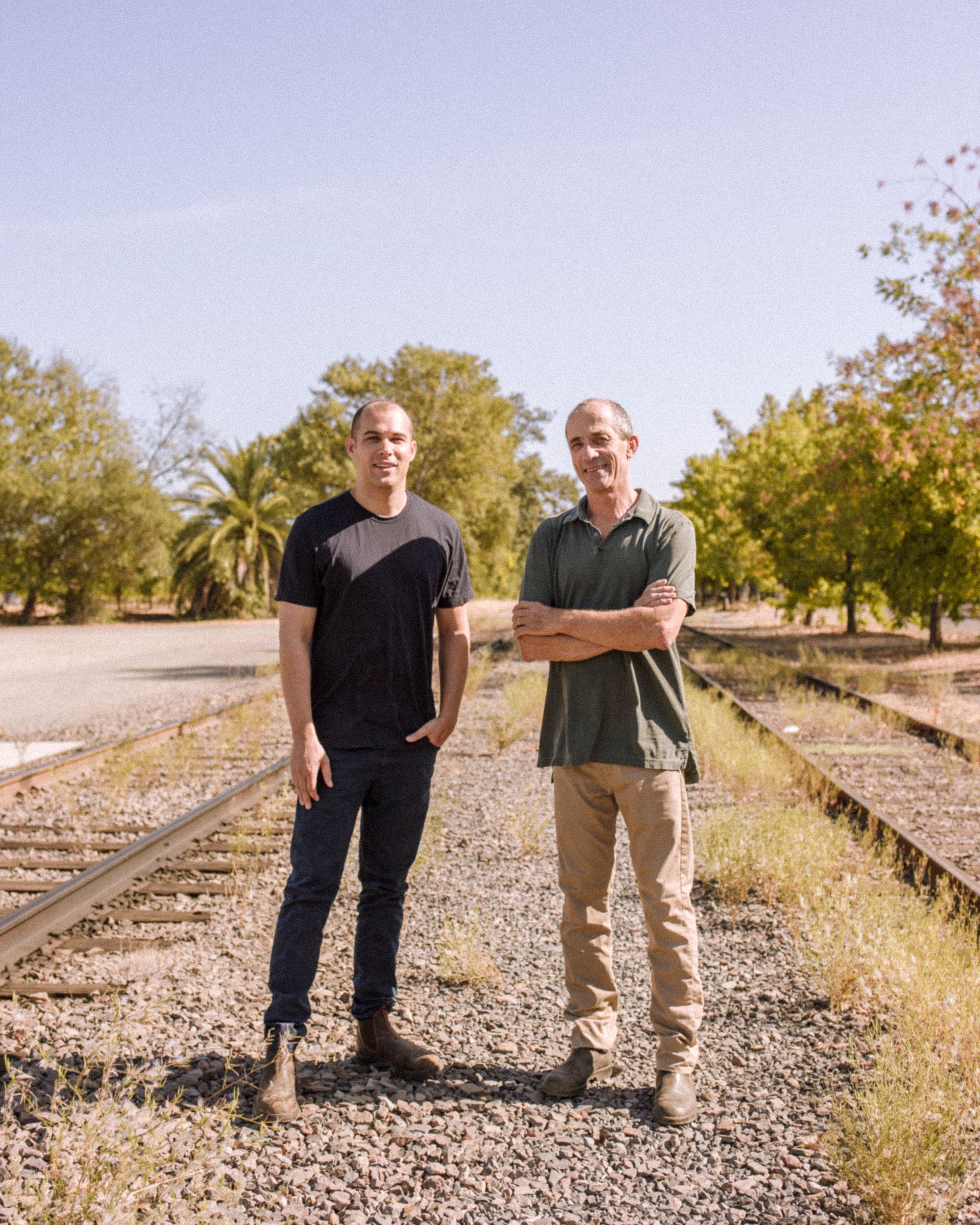 Winemakers of Grounded Wine Co, with the vineyard on the background.