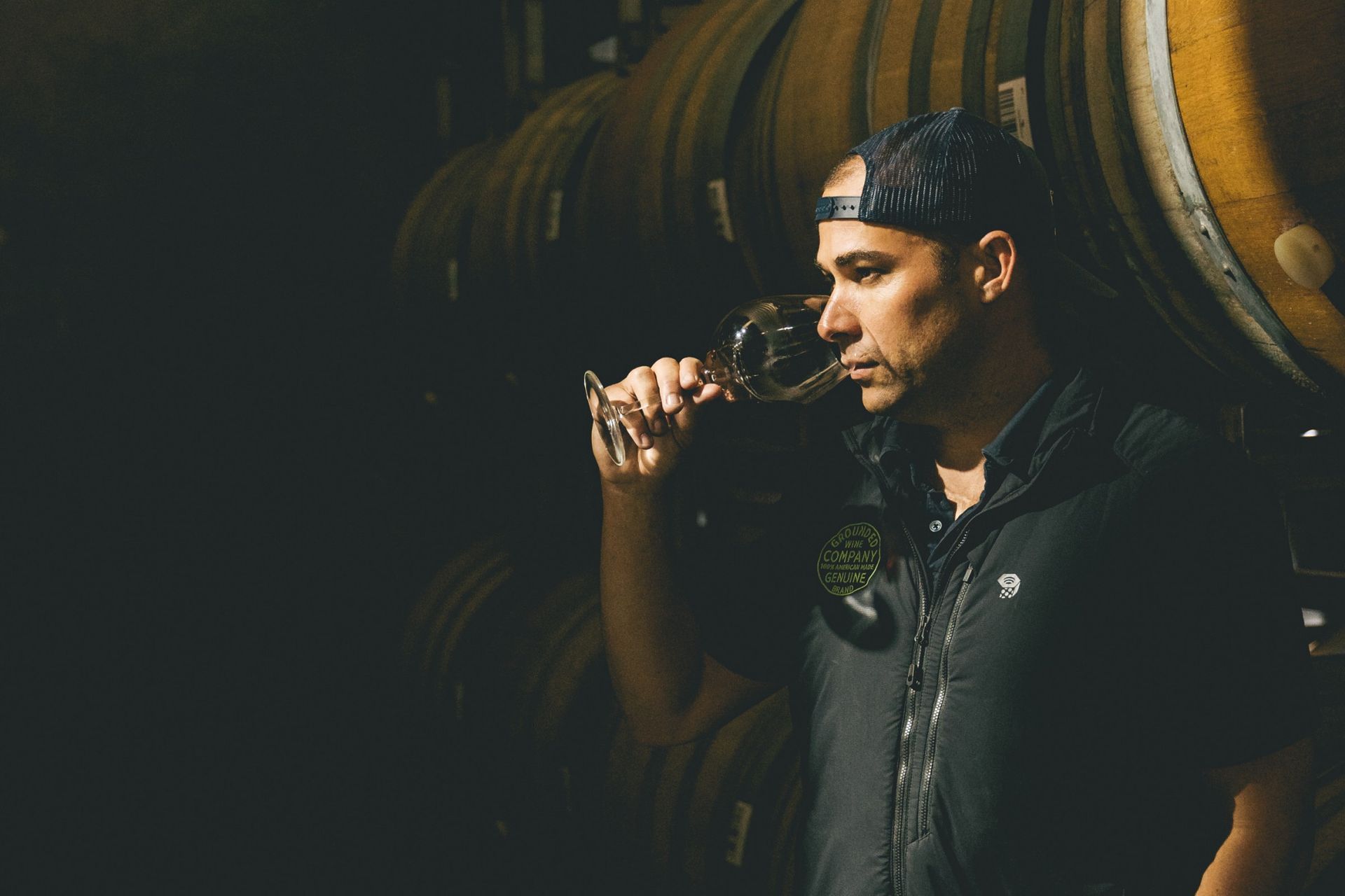 Winemaker of Grounded Wine Co tasting a wine in the cellar.
