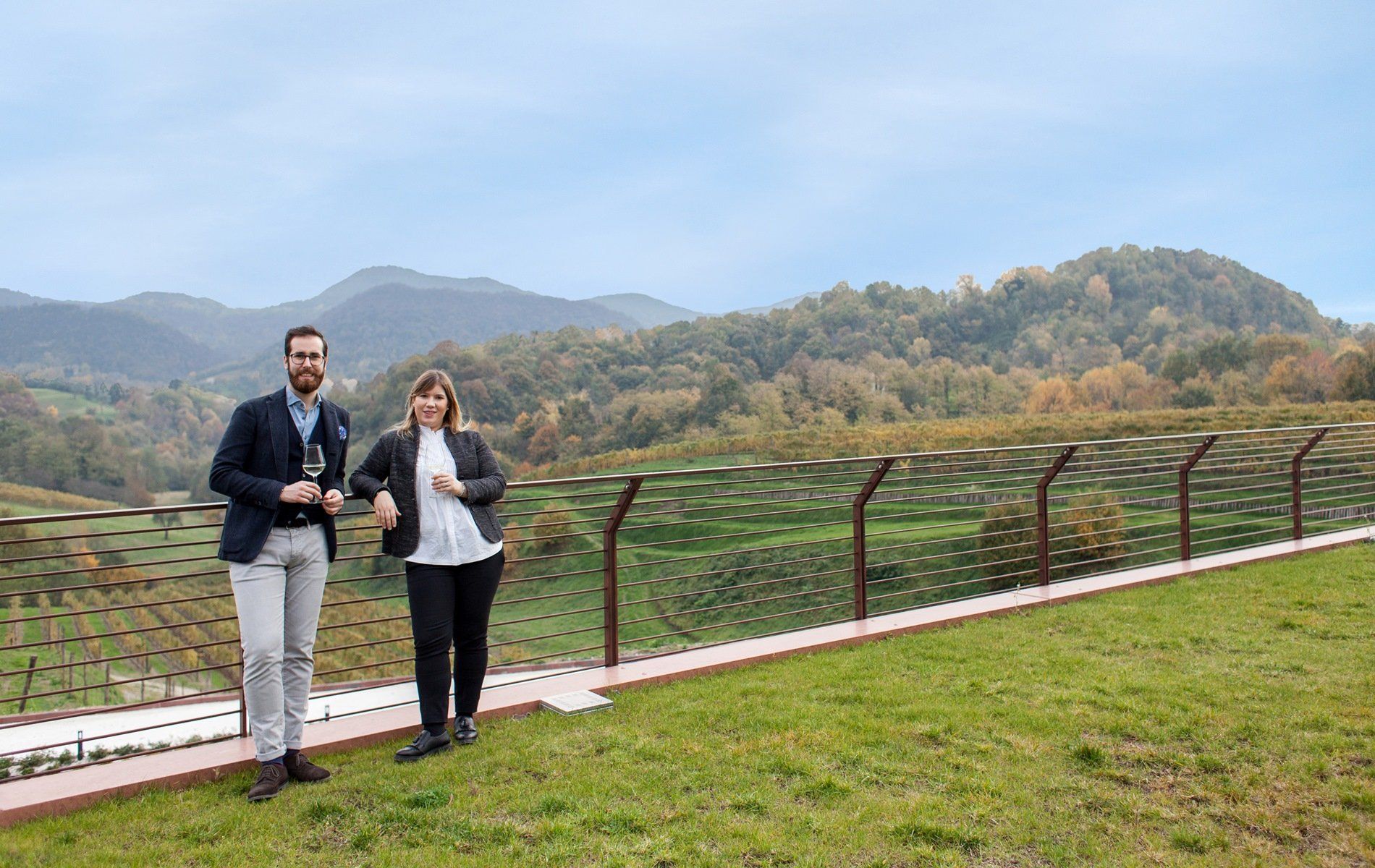 Winemakers of Tenuta Amadio standing near a vineyard, mountains in background.