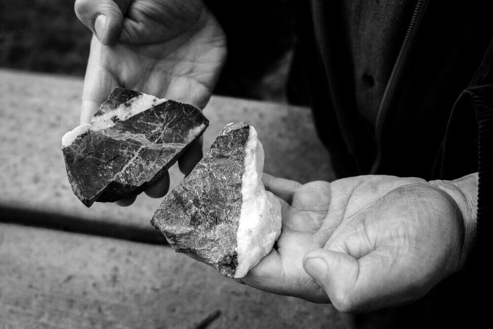 Hands holding two broken rocks, showing the internal patterns and colors, at Domaine Belargus